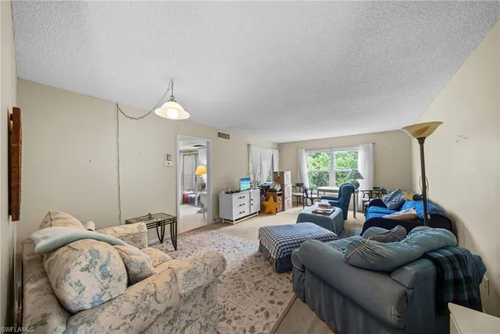 Living area with carpet floors and a textured ceiling