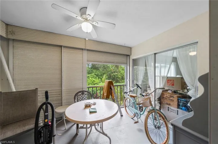 Sunroom / solarium with a ceiling fan, a balcony, and concrete floors
