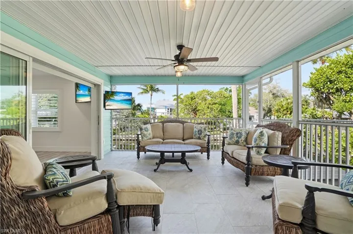 Sunroom / solarium featuring an outdoor hangout area and a ceiling fan - Virtually Edited Image
