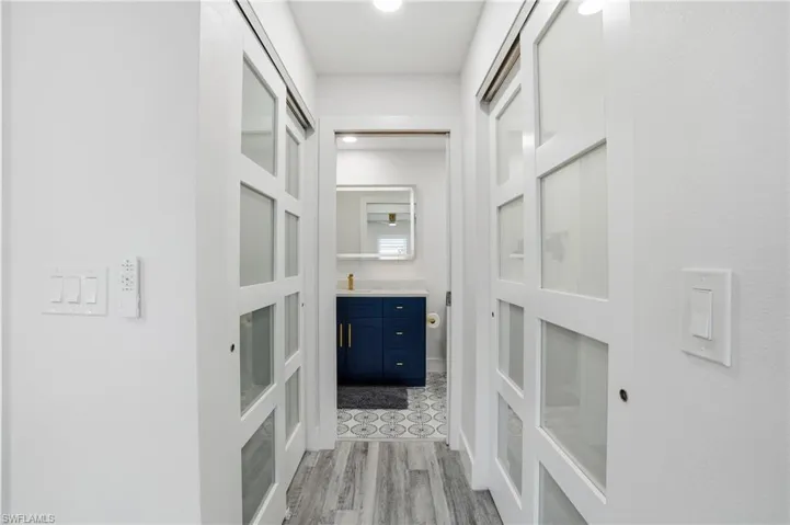 Corridor with light wood-style flooring and a sink - Virtually Edited Image