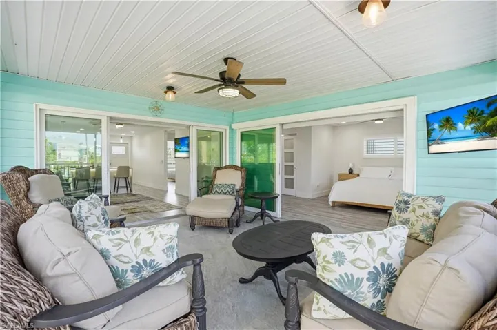 Sunroom featuring outdoor lounge area, ceiling fan, and healthy amount of natural light - Virtually Edited Image