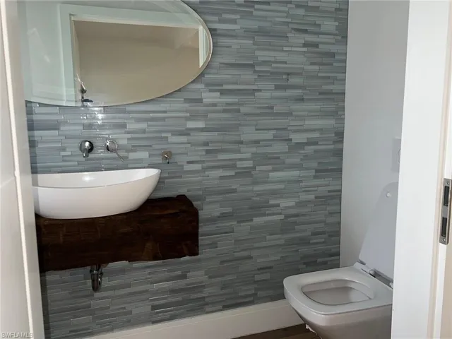Half bathroom featuring tile walls and tasteful backsplash