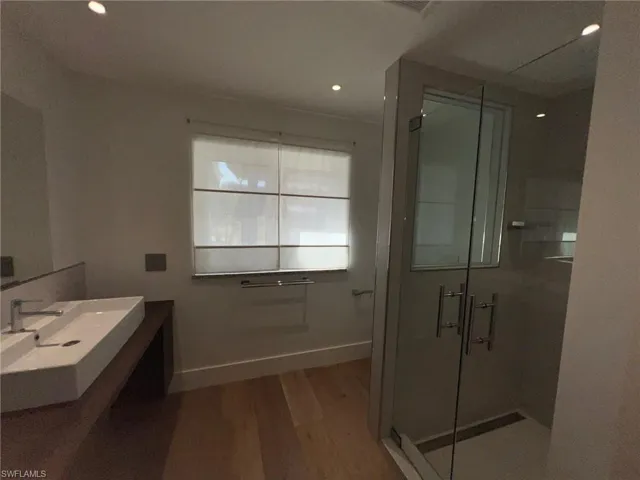 Full bathroom with a shower stall, vanity, dark wood-style flooring, and recessed lighting