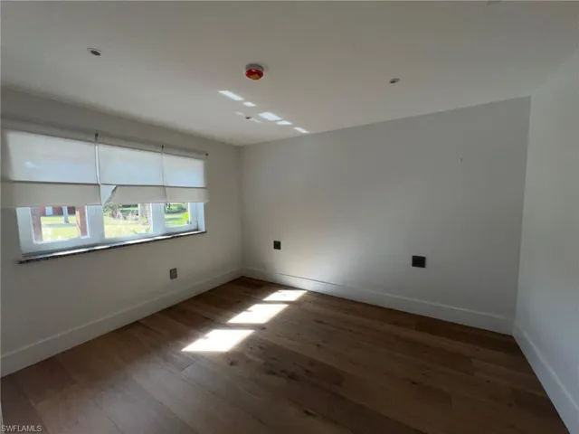 Spare room featuring wood finished floors and baseboards
