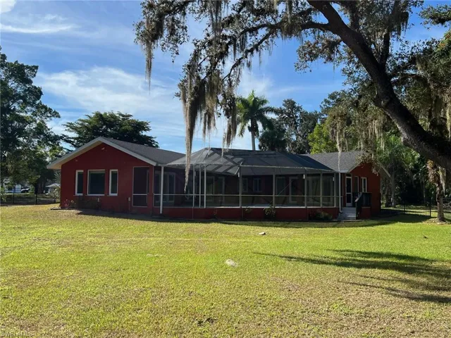 Rear view of house featuring glass enclosure and a sunroom