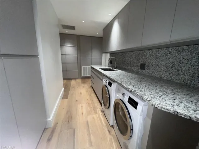 Washroom featuring light wood-type flooring and washer and dryer
