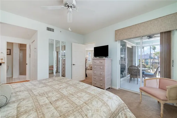 Carpeted bedroom with ceiling fan and access to outside