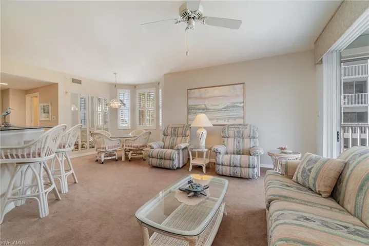 Living room featuring light colored carpet and ceiling fan