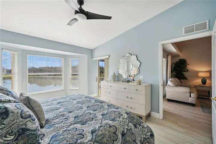 Bedroom with ceiling fan, lofted ceiling, and light wood-type flooring
