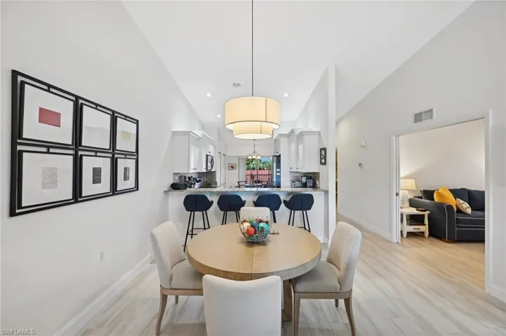 Dining room featuring light wood-type flooring and high vaulted ceiling