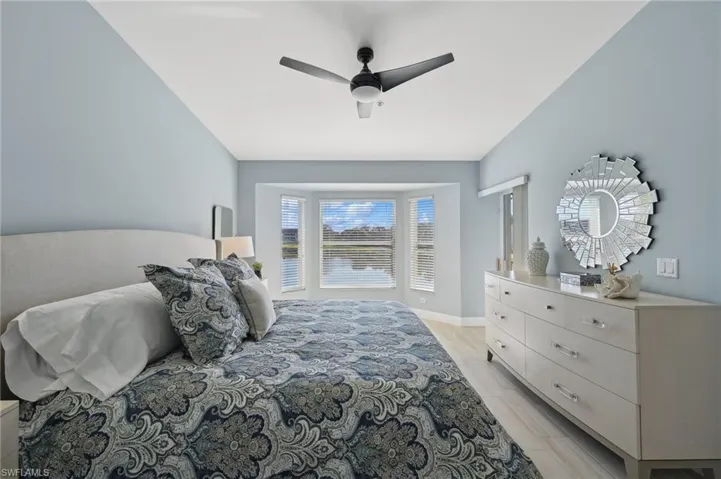 Primary Bedroom with light hardwood / wood-style floors, ceiling fan, and lofted ceiling