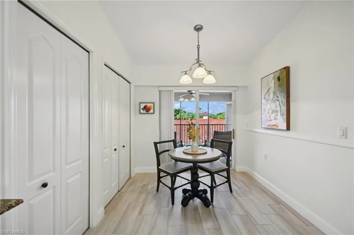 Breakfast area featuring light hardwood / wood-style flooring, lofted ceiling, and a notable chandelier
