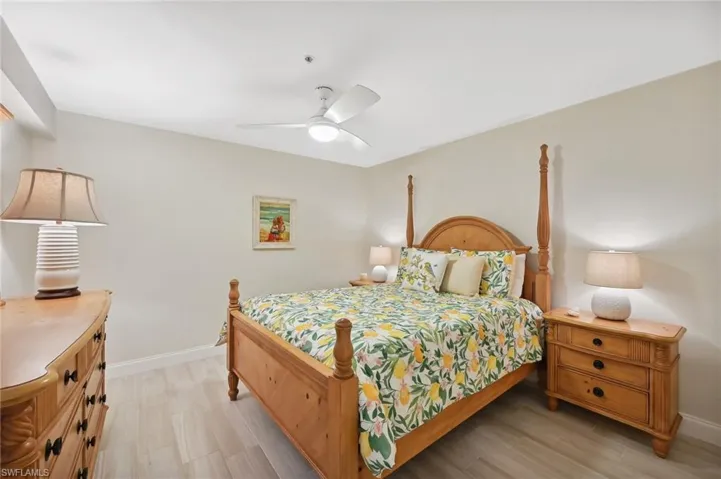 Guest Bedroom with light hardwood / wood-style floors and ceiling fan