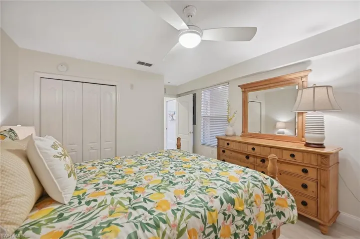 Guest Bedroom with ceiling fan, light wood-type flooring, and a closet