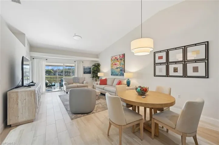 Dining area with lofted ceiling and light hardwood / wood-style flooring