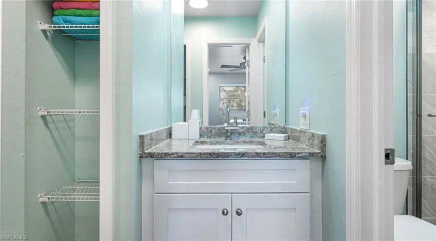 Bathroom with toilet, ceiling fan, and vanity