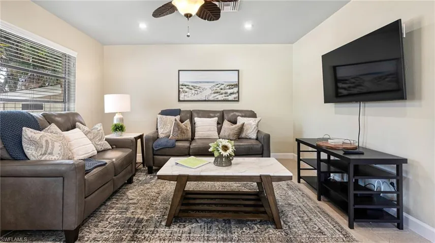 Living room with ceiling fan, recessed lighting, visible vents, and baseboards