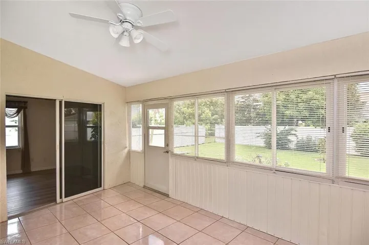 Unfurnished sunroom featuring lofted ceiling