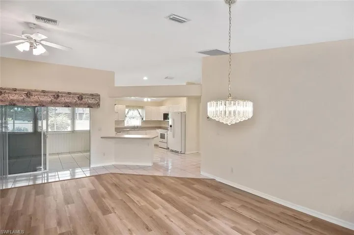 Unfurnished dining area with a chandelier, light wood-style flooring, and ceiling fan