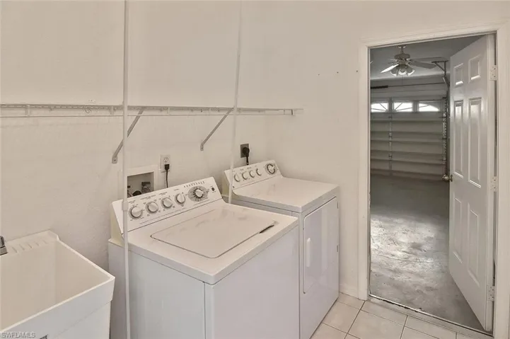Washroom featuring independent washer and dryer, light tile patterned flooring, and a ceiling fan