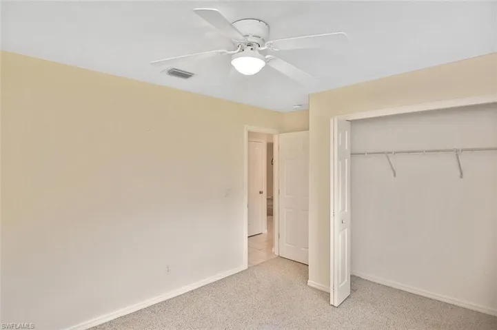 Unfurnished bedroom featuring a closet, carpet flooring, and a ceiling fan