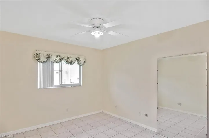 Unfurnished room with light tile patterned floors and a ceiling fan
