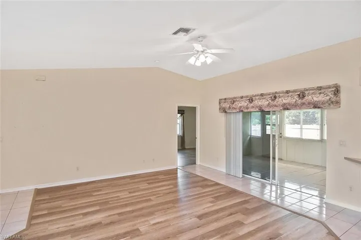 Unfurnished room with light wood-style floors, lofted ceiling, and ceiling fan