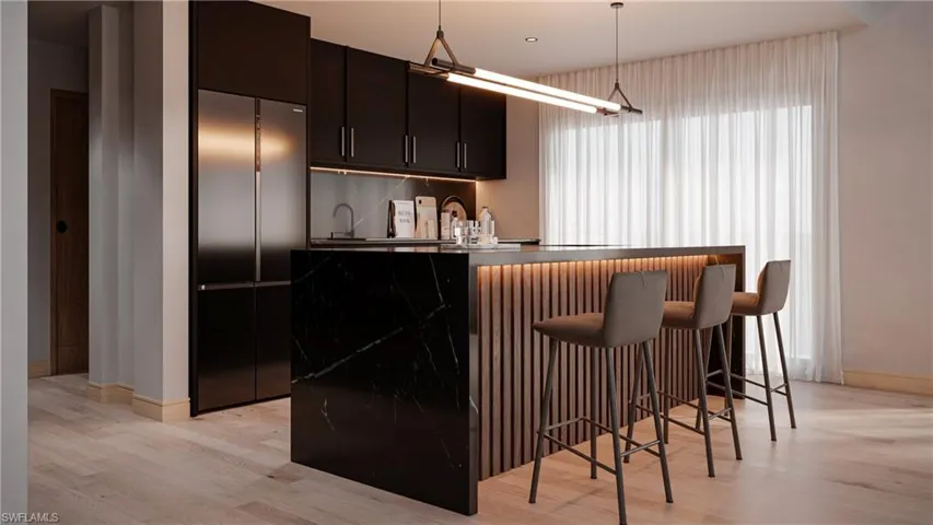 Bar area featuring built in refrigerator, light wood-style flooring, decorative light fixtures, dark cabinetry, and modern cabinets