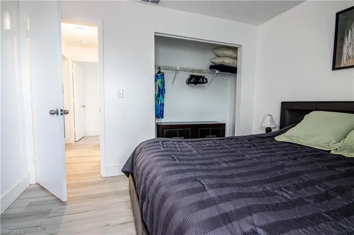 Bedroom with a closet, a textured ceiling, and light wood-style flooring