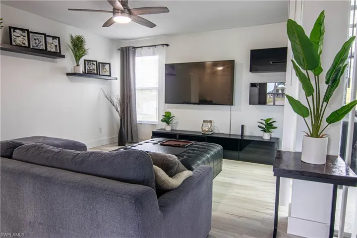 Living area with ceiling fan and light wood finished floors
