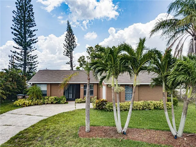 Single story home with a front yard, a shingled roof, and concrete driveway