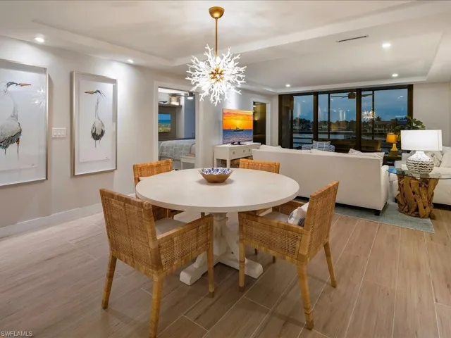 Dining room featuring recessed lighting, light wood-style flooring, a tray ceiling, and a chandelier