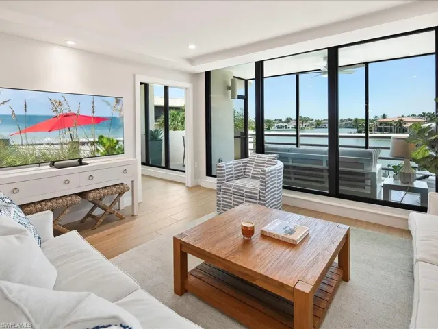 Living area with wood finished floors, a water view, and recessed lighting