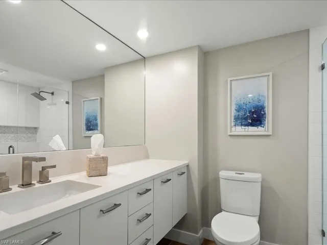 Full bathroom with a stall shower, vanity, recessed lighting, and backsplash