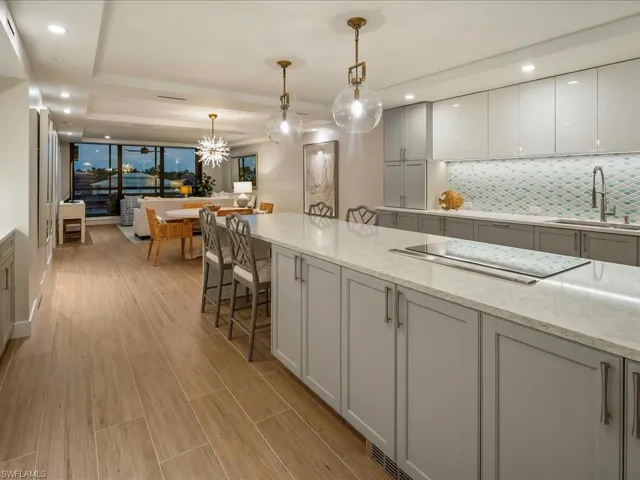 Kitchen featuring recessed lighting, tasteful backsplash, light stone countertops, gray cabinets, and pendant lighting