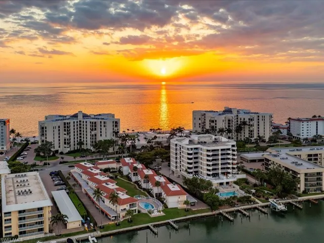 Aerial view at dusk of a water view and view of pool area