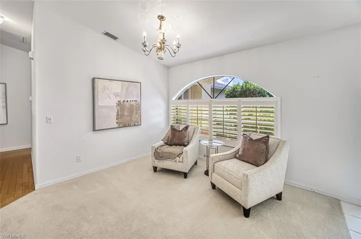 Living area featuring a chandelier and carpet