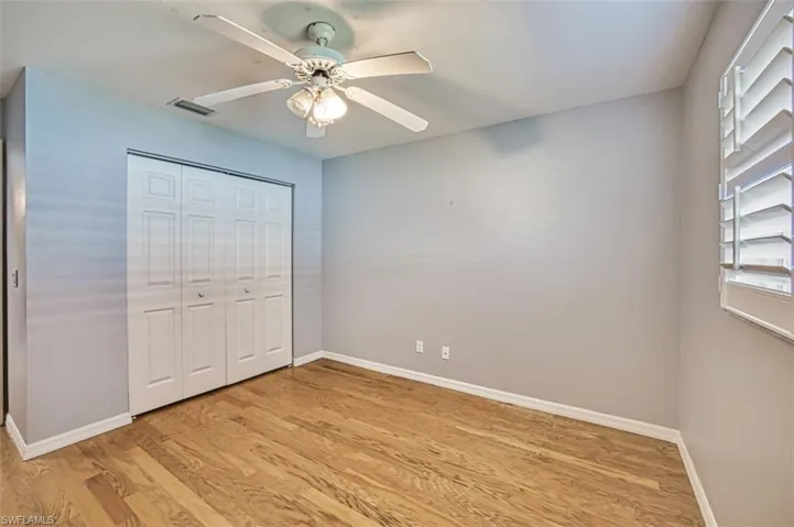 Unfurnished bedroom featuring light hardwood / wood-style floors, a closet, and ceiling fan