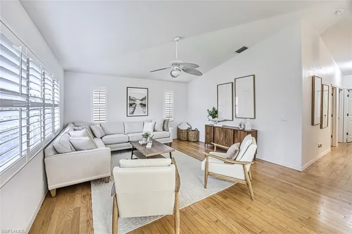 Living room featuring lofted ceiling, light hardwood / wood-style floors, and ceiling fan