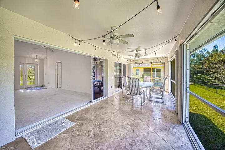 Unfurnished sunroom with rail lighting and ceiling fan