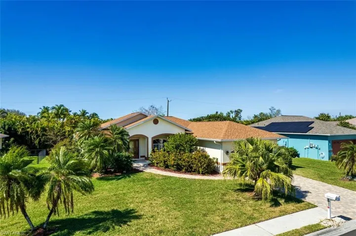 View of front of house with solar panels and a front yard