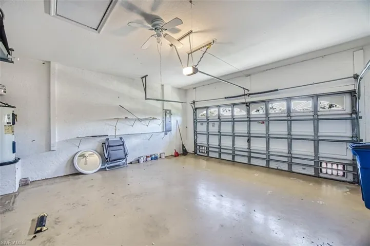Garage featuring a garage door opener, electric panel, and ceiling fan