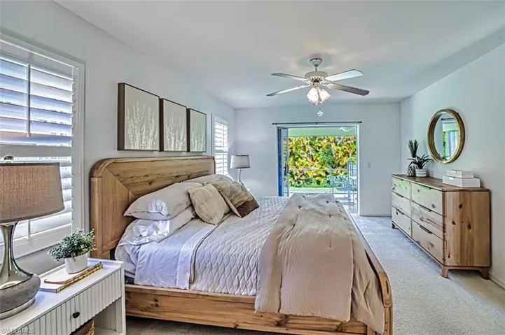 Carpeted bedroom featuring access to exterior and ceiling fan