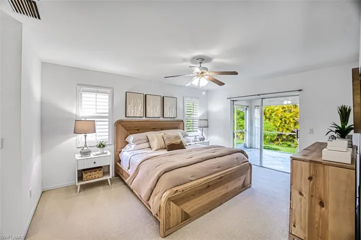 Carpeted bedroom with access to outside and ceiling fan