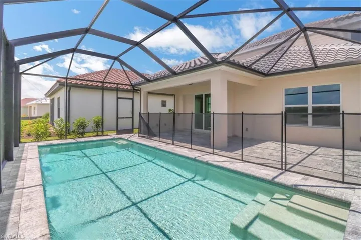 Outdoor pool featuring a sunroom, a patio, and a lanai