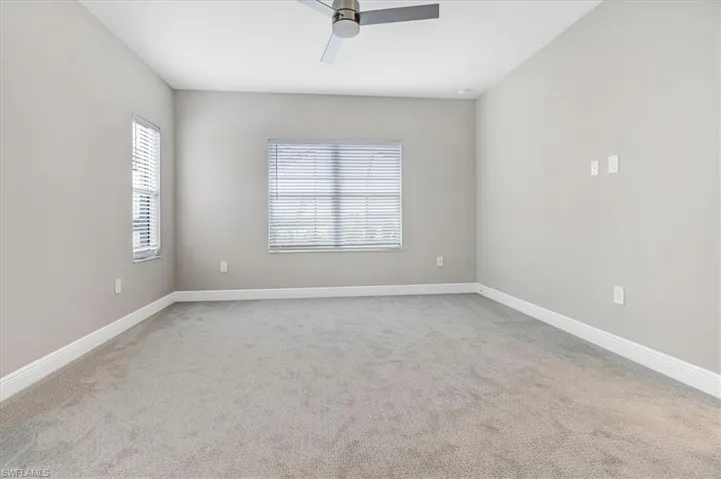 Unfurnished room with a ceiling fan and light colored carpet