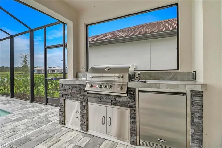 View of patio featuring a lanai, area for grilling, an outdoor pool, and a sunroom