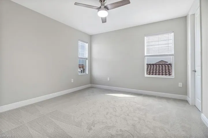 Unfurnished room with light carpet and a ceiling fan