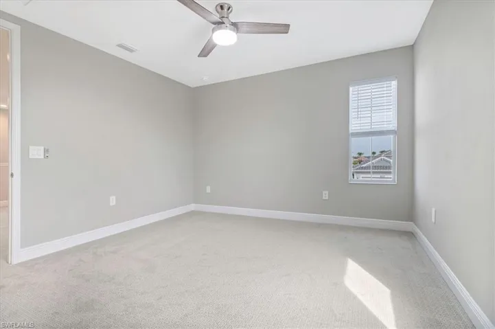 Unfurnished room featuring light colored carpet and a ceiling fan