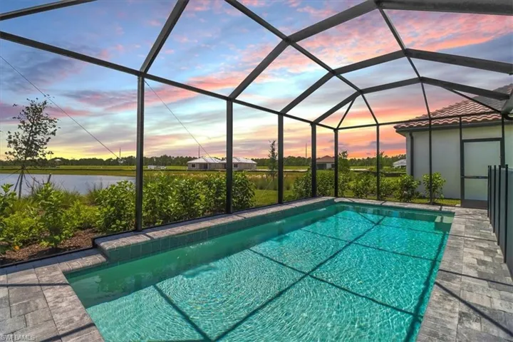 Outdoor pool featuring a sunroom and glass enclosure